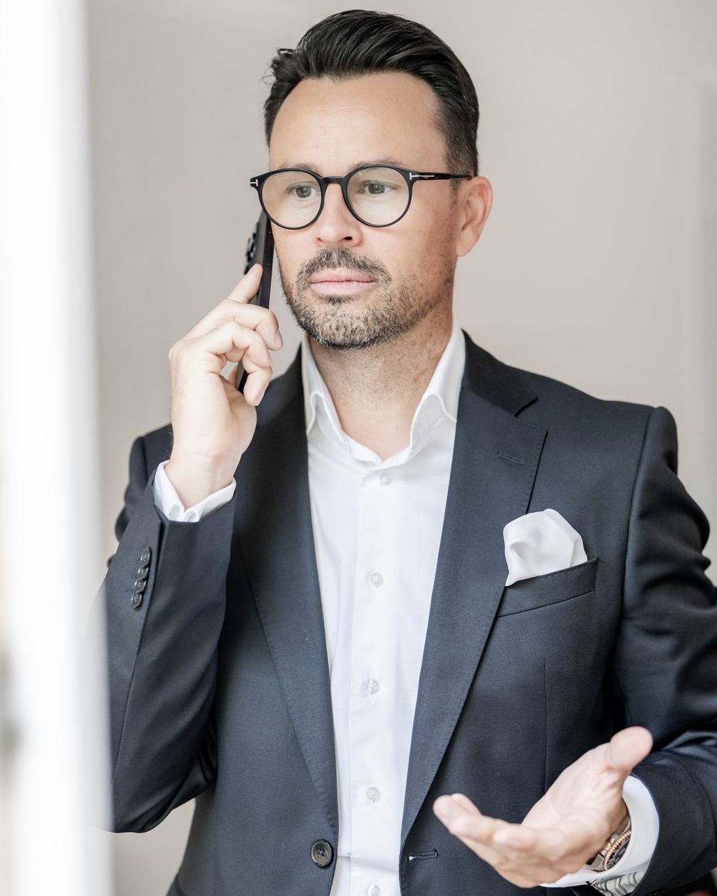 Manfred Braun telefoniert und erklärt mit der Hand